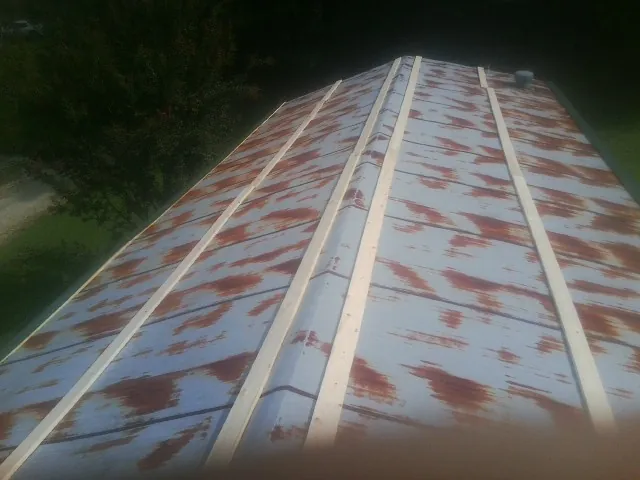 Rusted metal roof panels with new wood purlins before replacement — Storm Damage Roof Repair in Gillette by Roofing Brothers