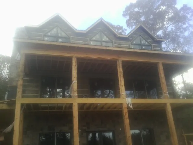 Dormers and porch framing on a large log home under construction — Roof Coating work by our crew in Gillette